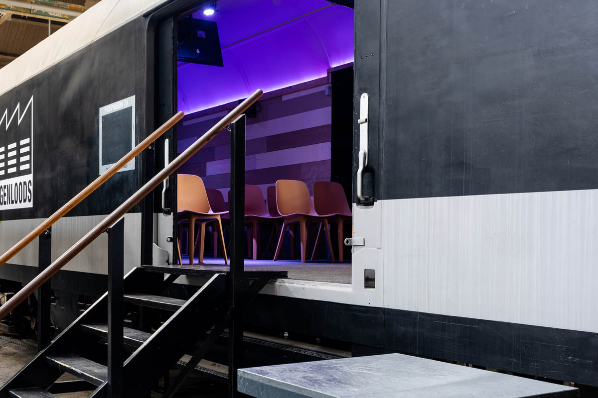 Ingerichte treinwagon in De Rijtuigenloods met stoelenopstelling en schermen voor presentatie of break-outsessie